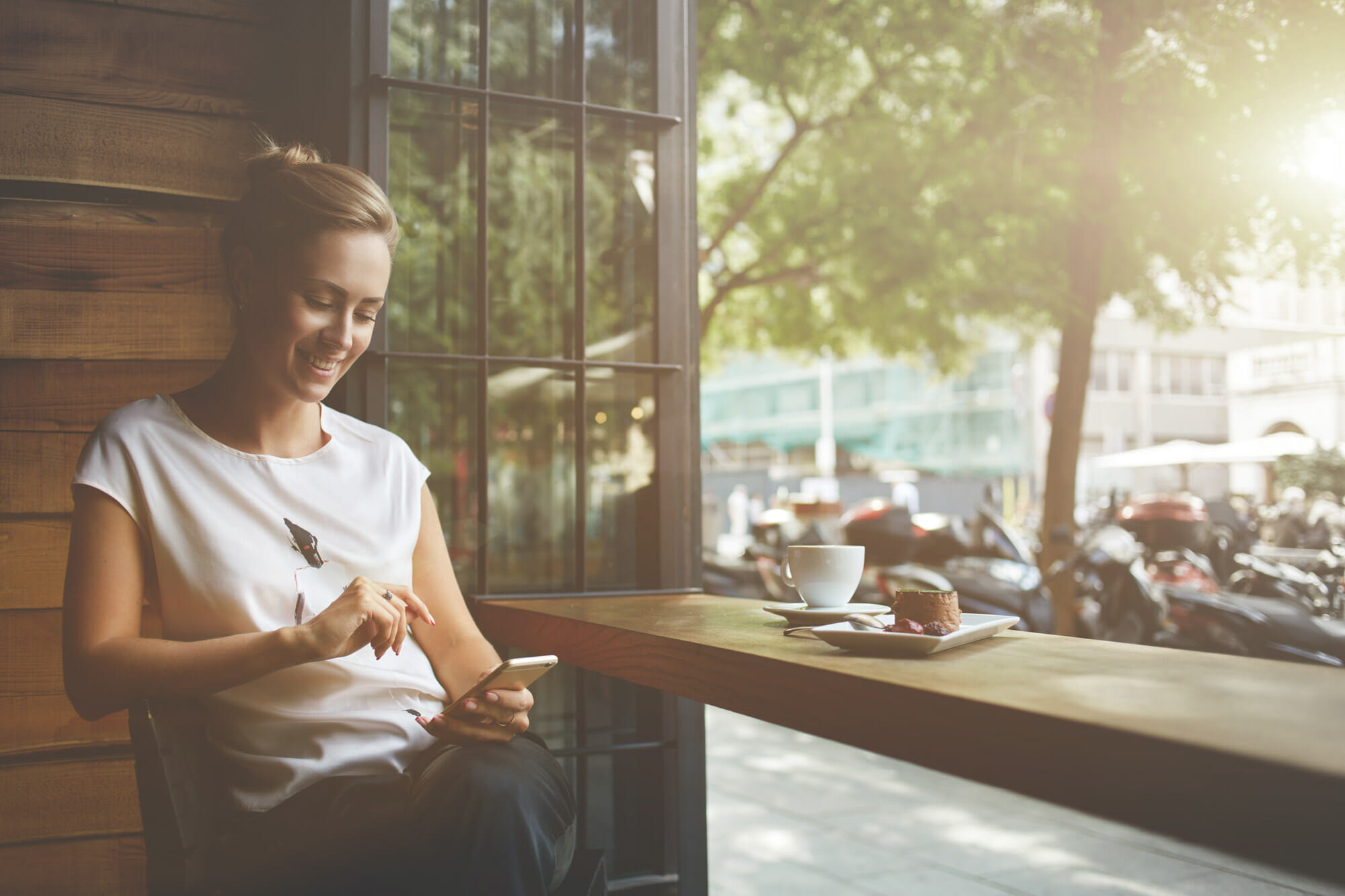 Estate Planning - Woman Enjoying Alone Time at Café, Checking Her Phone