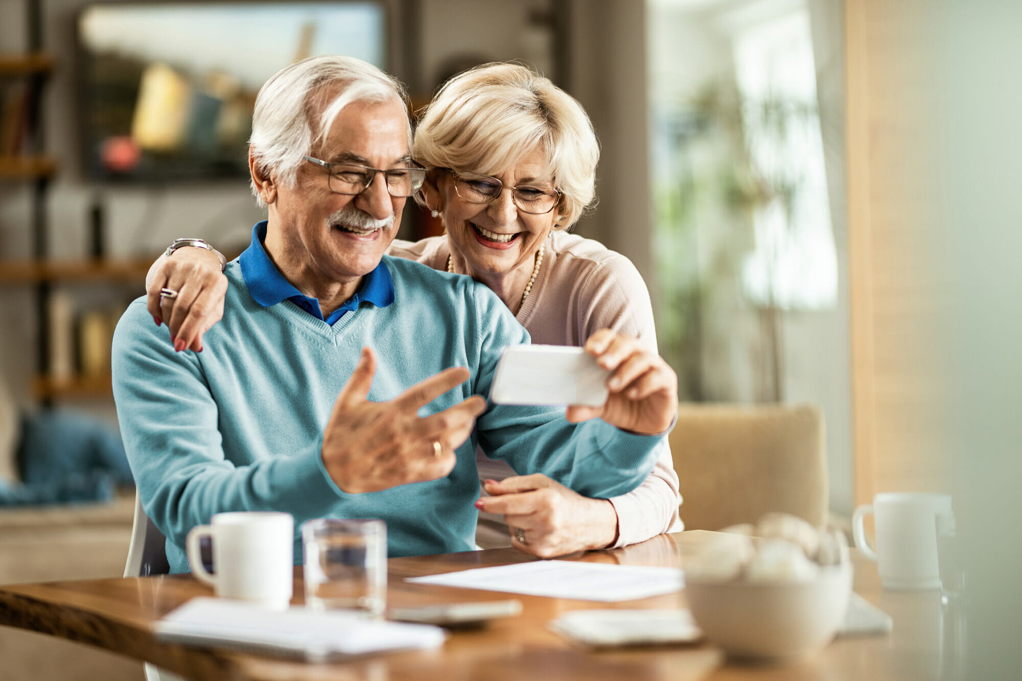 Tax Planning - Couple Strategizing on Mobile Phone in Dining Room