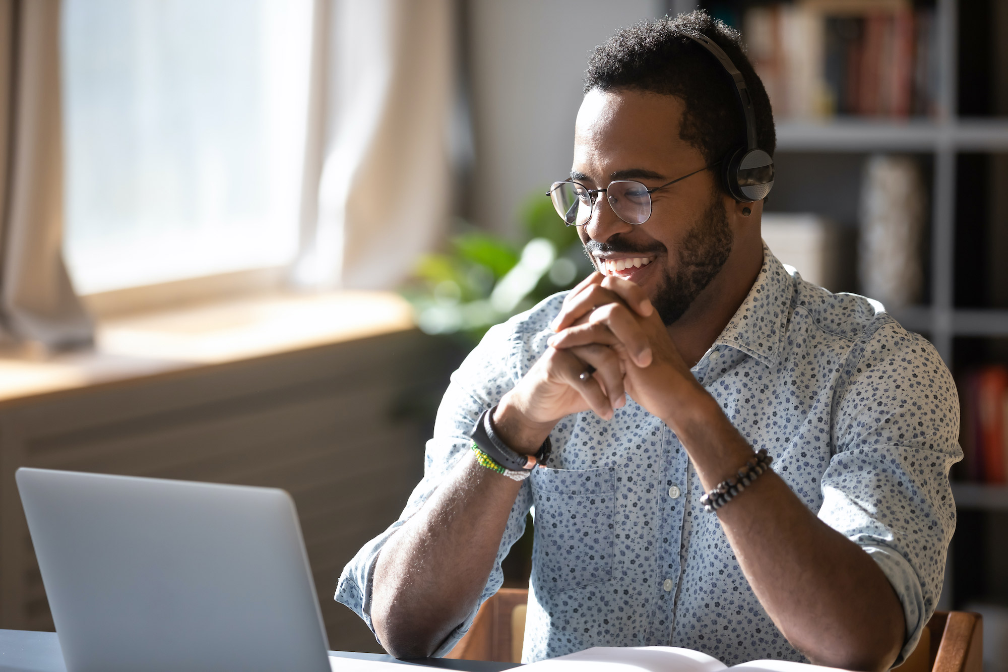 Specialized Services - Man Laughing with Laptop and Headphones in Comfortable Home Environment