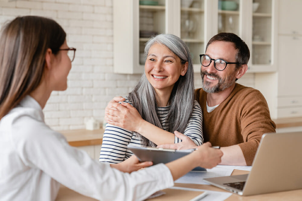 Retirement Planning - Couple Interviewing with Woman Using Notebook in Comfortable Environment