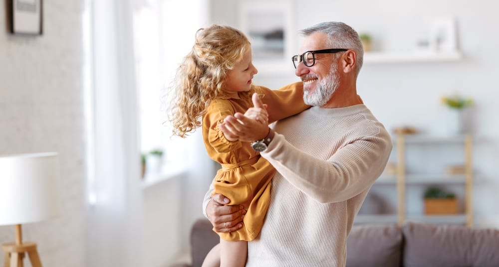 Retirement Planning - Grandfather Playing with Granddaughter in Cozy Home Environment