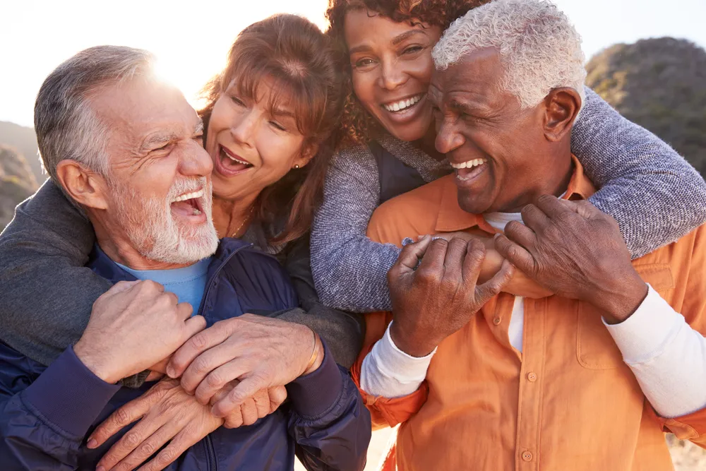 Retirement Workshop - Two Elderly Couples Laughing and Enjoying Time Together Outdoors